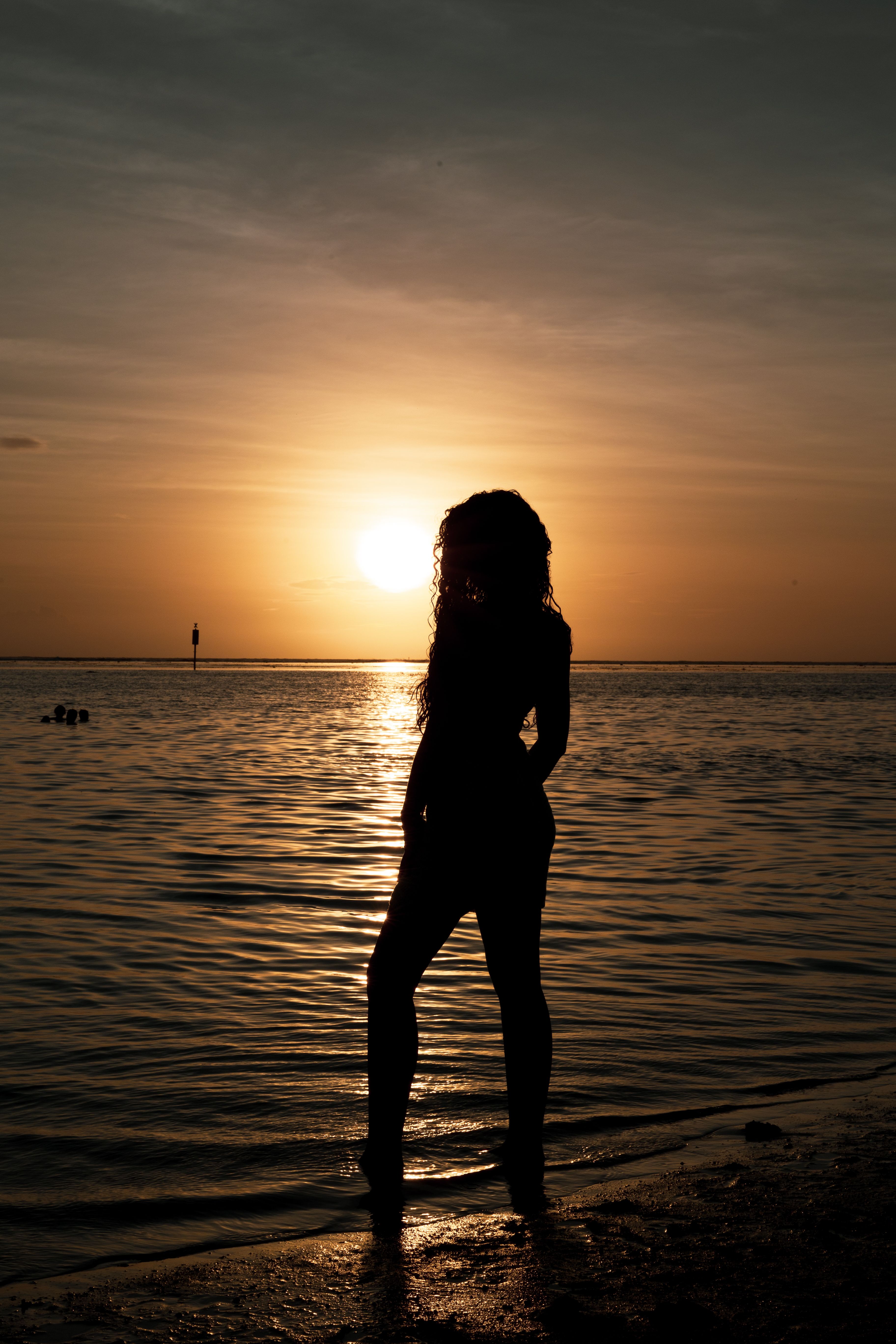 Silhouette of Woman by Ocean at Sunset · Free Stock Photo