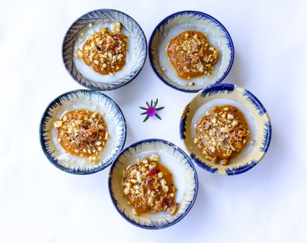 Traditional Vietnamese bánh bèo rice cakes topped with savory nut and shallot mix.