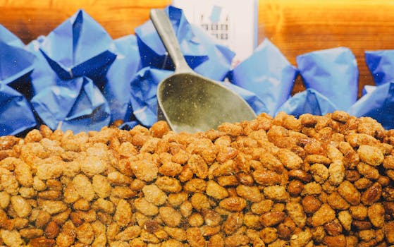 Close-up of sugared roasted almonds with blue wrapping at a Berlin market stall.