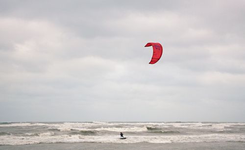 Free A kitesurfer enjoying the waves under a cloudy sky in Taoyuan, Taiwan. Stock Photo
