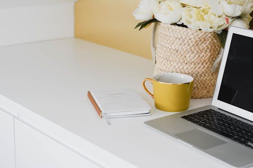 Free Yellow Mug Besides Laptop Stock Photo