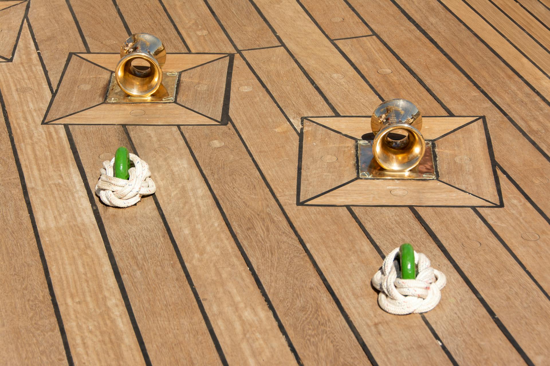 Close-up of yacht deck with brass cleats and tied rope, ideal for maritime or nautical themes.