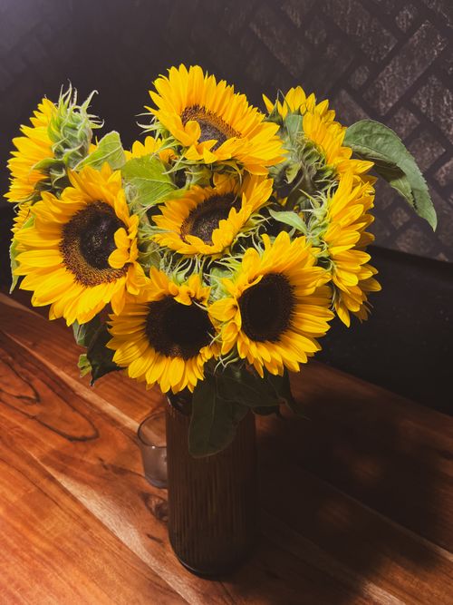 Free A bright sunflower arrangement in a vase on a wooden table indoors. Stock Photo
