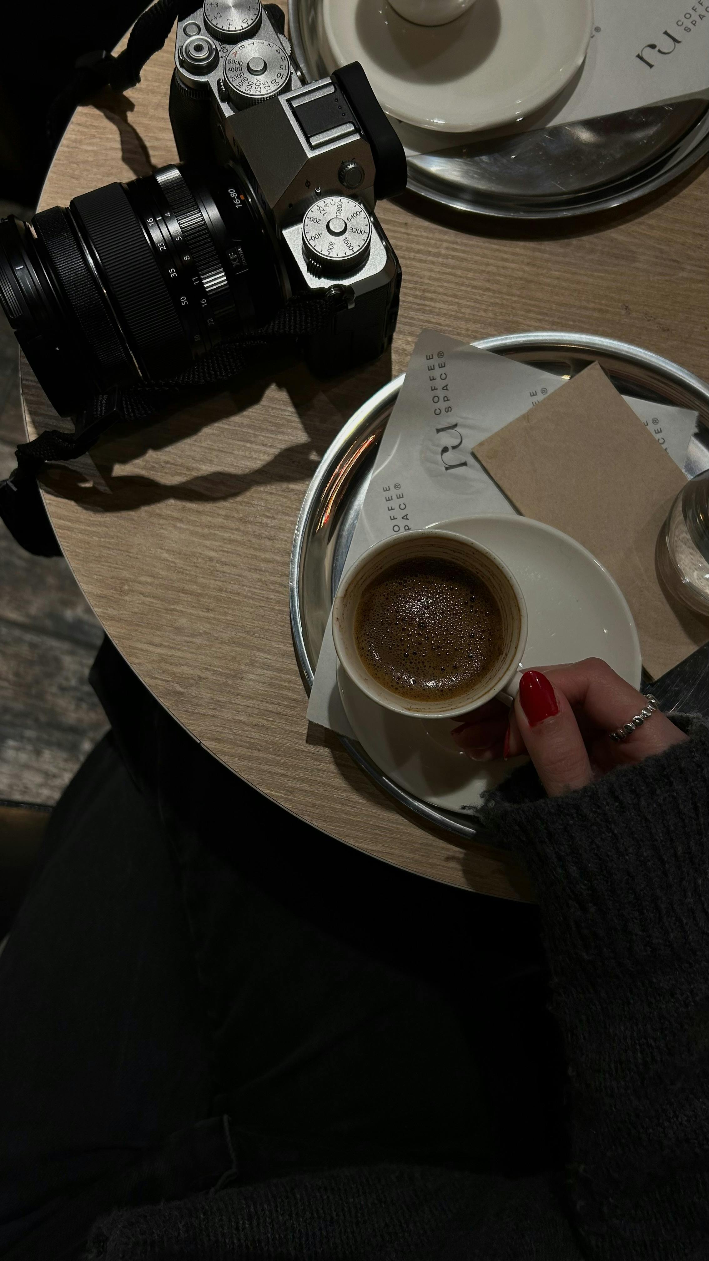 Stylish coffee setup with a camera on a cafe table, creating an Instagram-worthy moment.