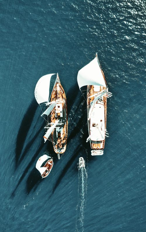 Free Stunning aerial view of sailboats navigating the calm, open blue sea. Stock Photo