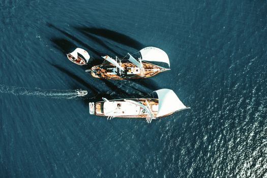 Aerial view of sailboats navigating the blue ocean, capturing the beauty of marine travel.