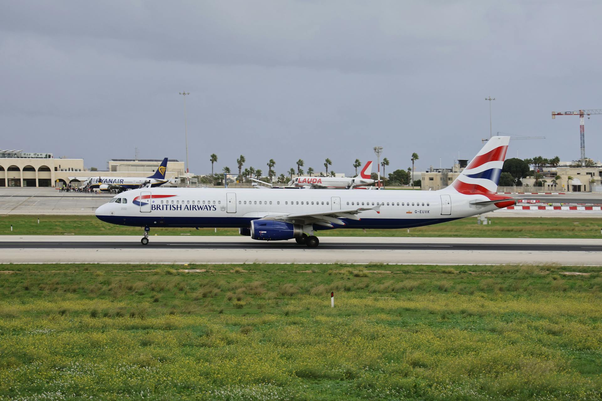 British Airways Airbus A321 ready for departure on a cloudy day at an airport.