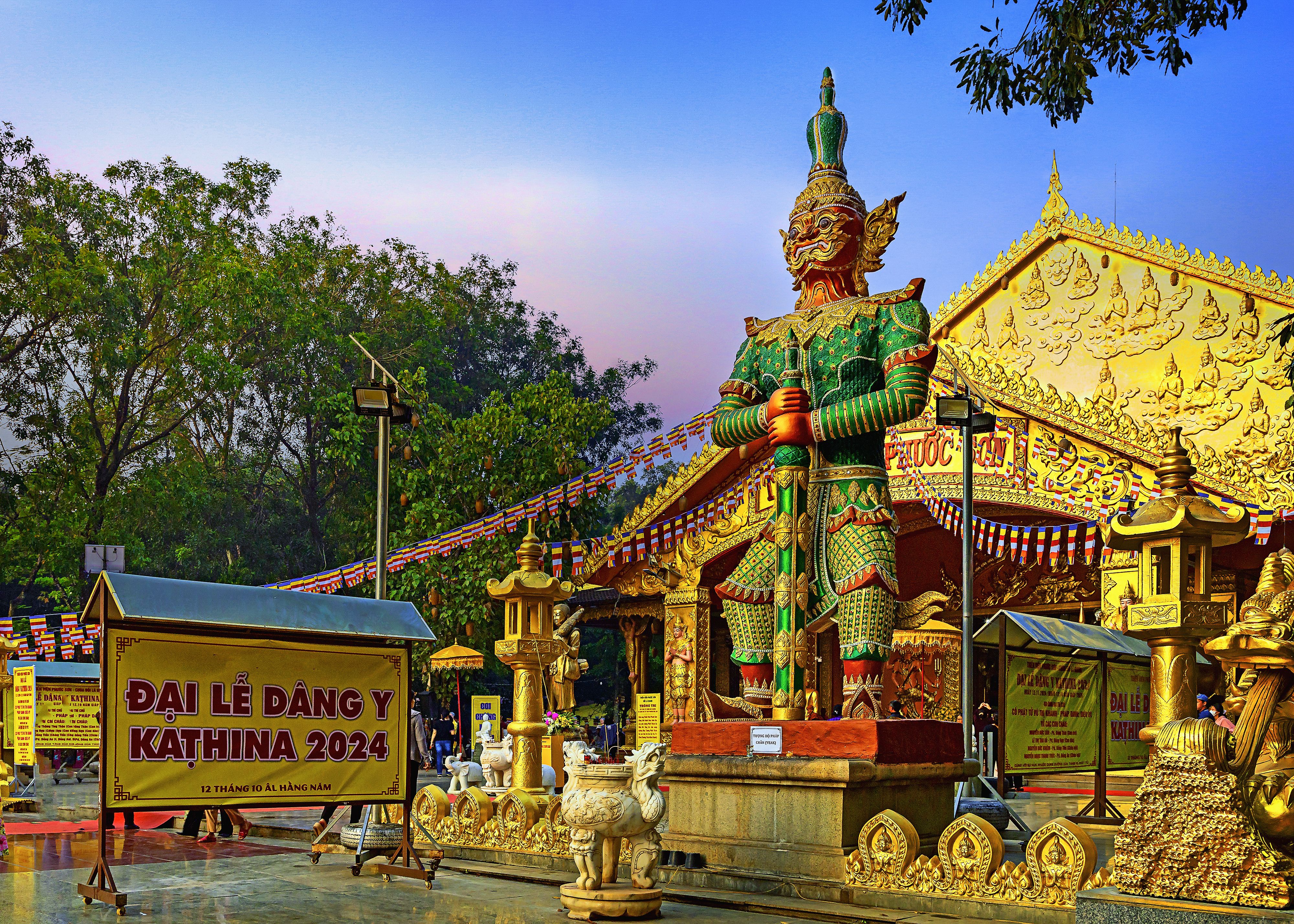 Vibrant golden statue at a temple in Đồng Nai, Vietnam during Kathina 2024 festival.