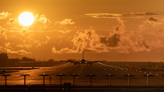 Airplane preparing for takeoff at Alajuela Airport with a dramatic sunset backdrop.