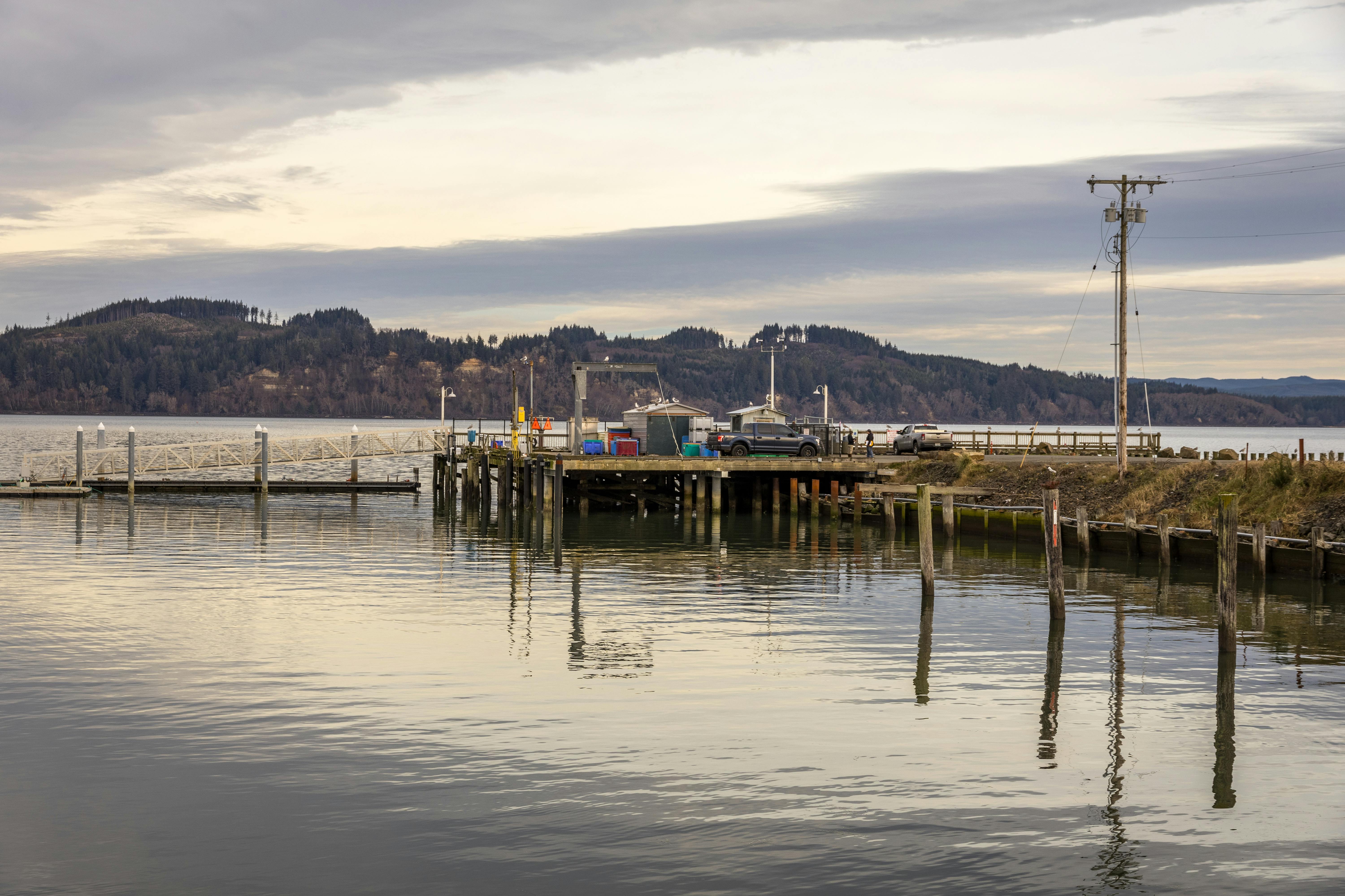 A tranquil view of the dock at Tokeland, WA, under cloudy skies with calm waters.