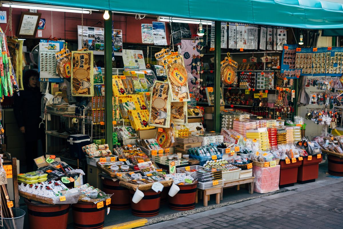 Souvenir shop in Tokyo with snacks, toys and traditional goods displayed outside on the street