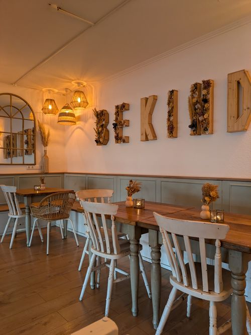 Free Charming cafe in Kiel with rustic decor and 'Be Kind' wall art. Stock Photo