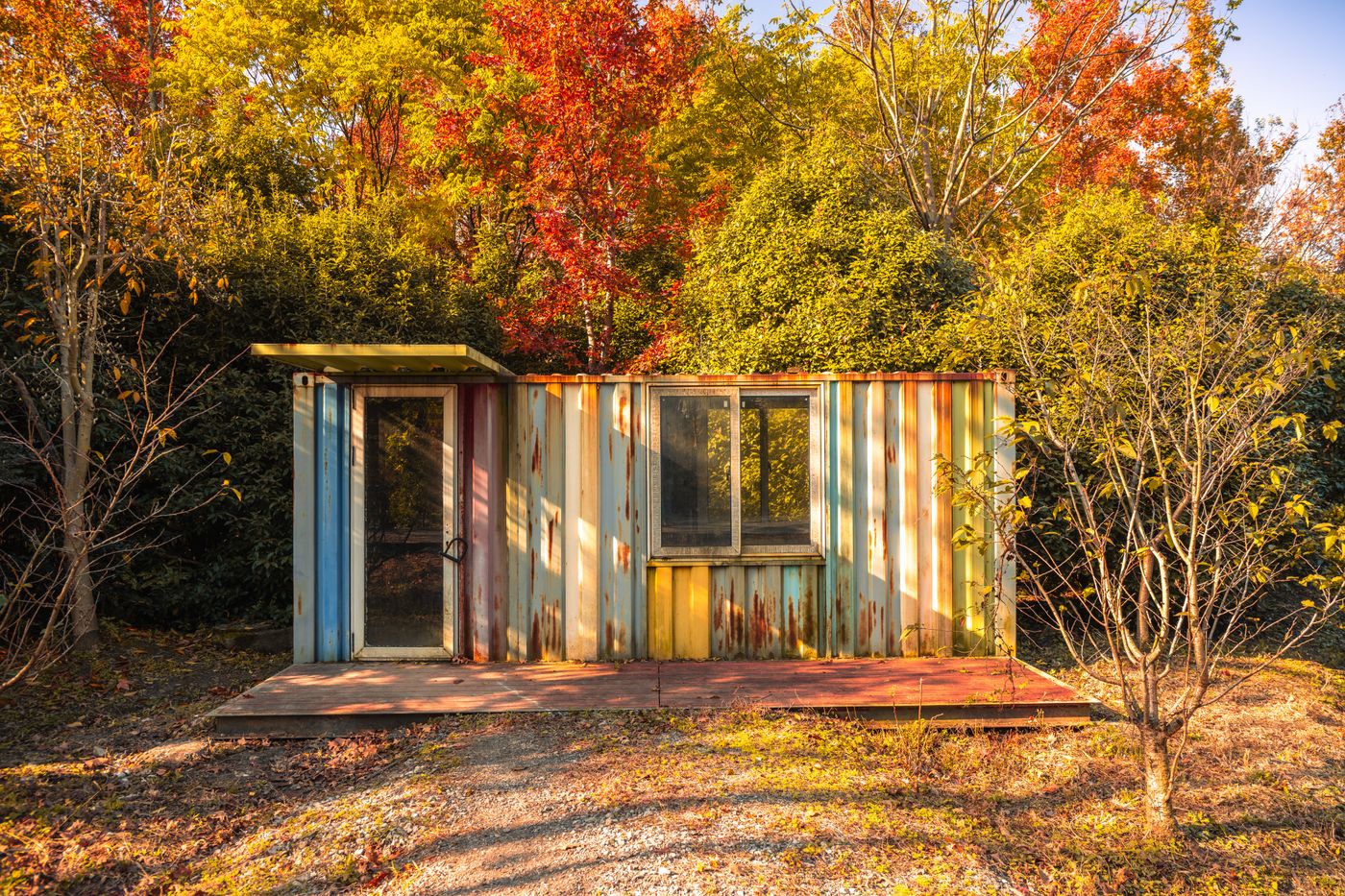Small cabin surrounded by autumn foliage