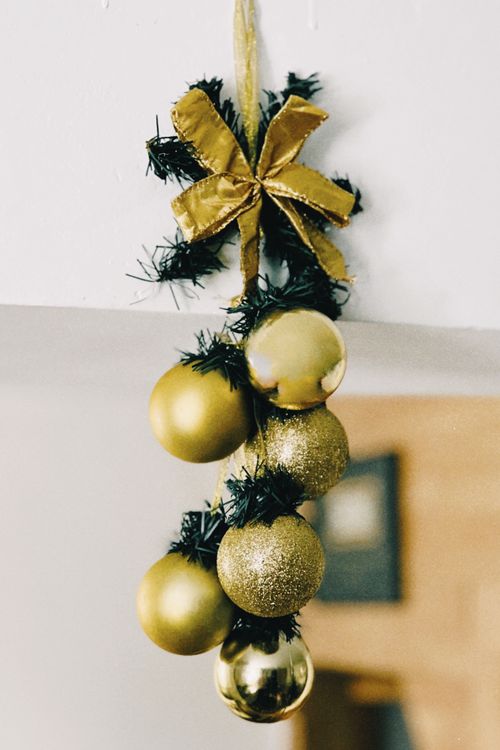 Free Elegant golden Christmas ornaments with ribbon and greenery for festive holiday décor. Stock Photo
