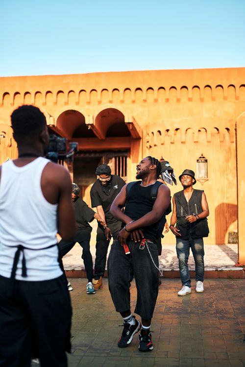 Free Energetic street dance performance by a group of young adults in an urban setting with historic architecture. Stock Photo