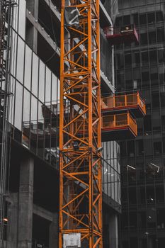 Dynamic view of an orange crane at a busy construction site in Warsaw, Poland.
