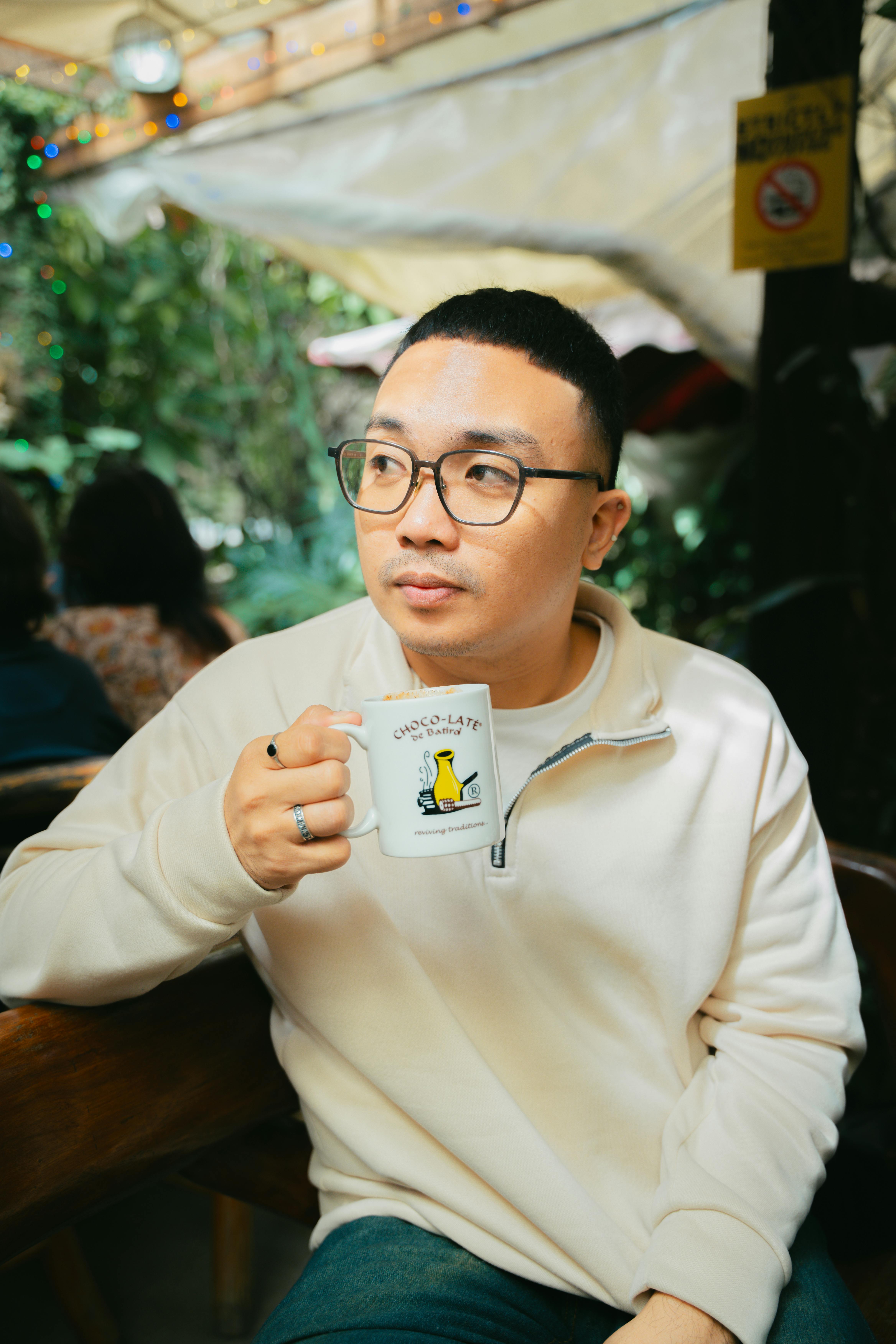 Man enjoying a coffee in an outdoor cafe. Casual and relaxed setting.