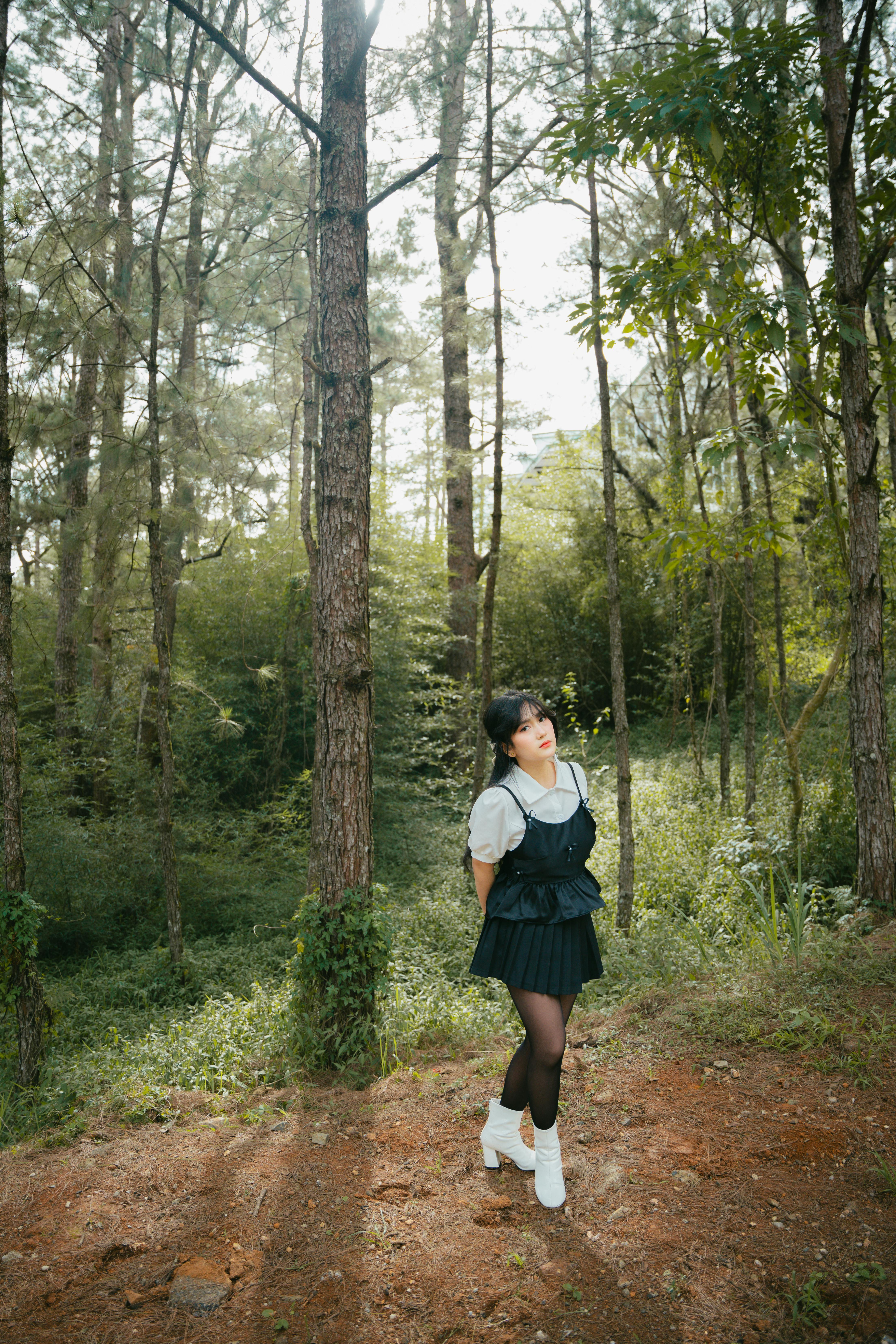 woman in forest with sunlight through trees