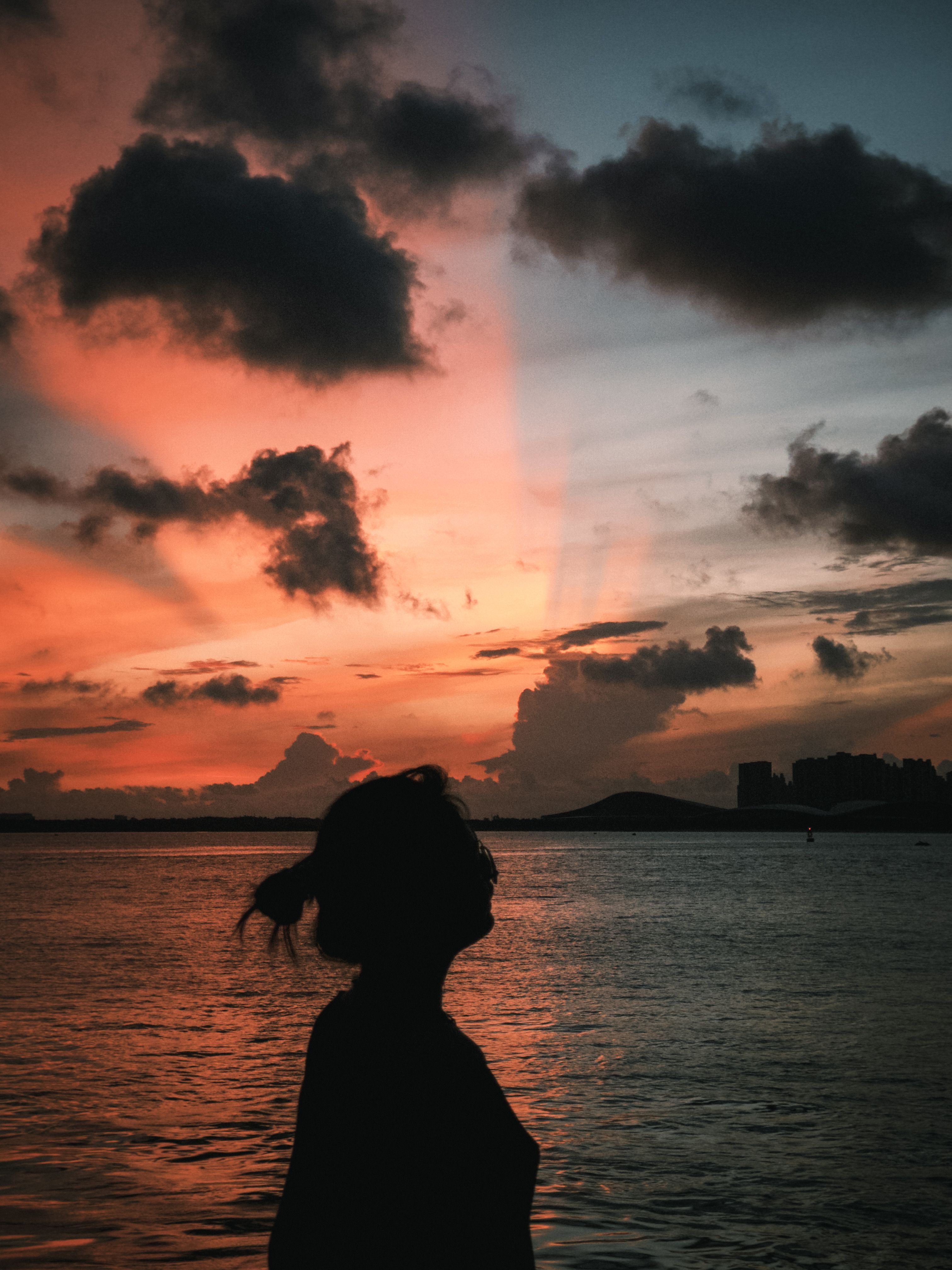 Silhouette of Woman at Dramatic Ocean Sunset · Free Stock Photo