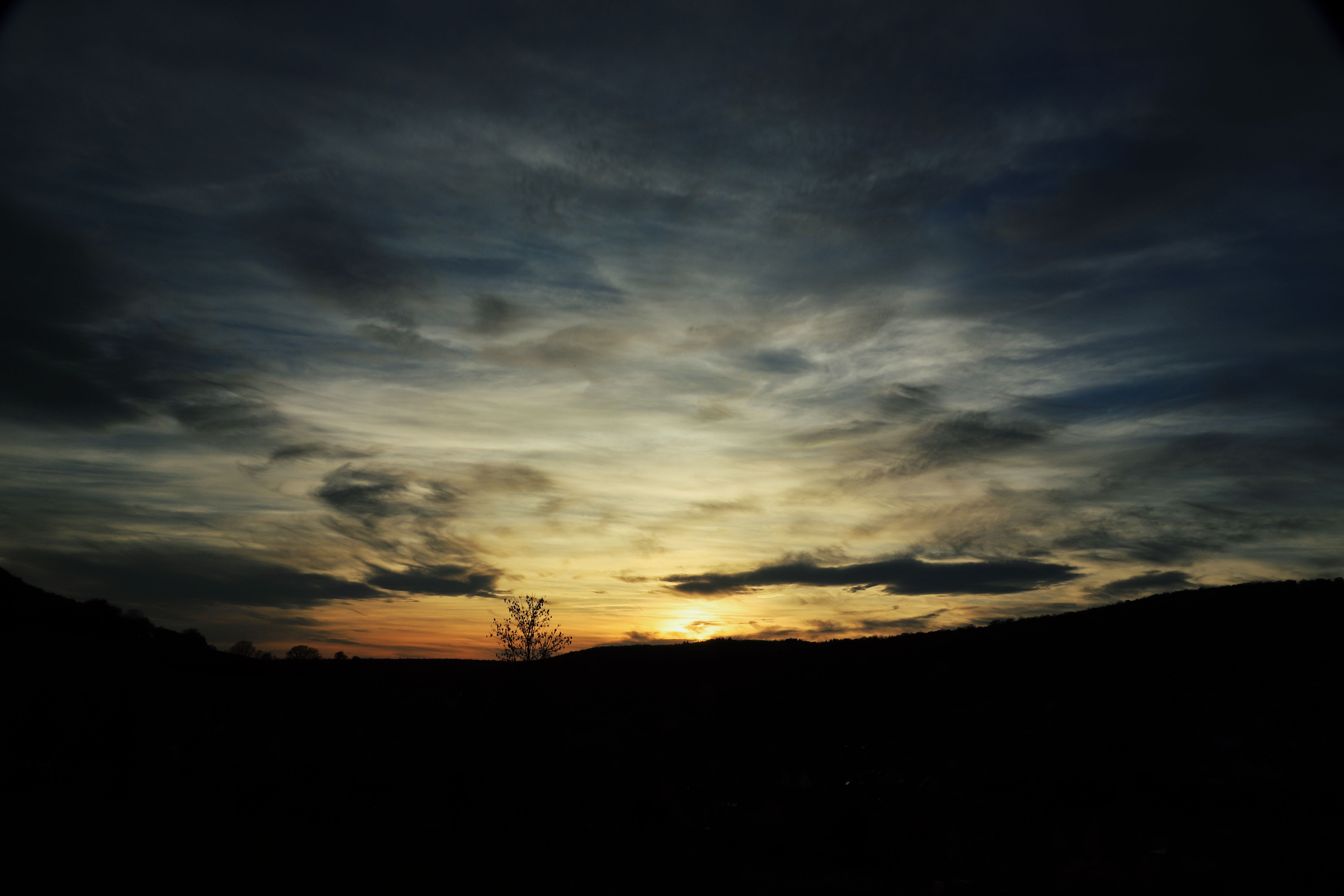Dramatic Sunset Over Rolling Hills · Free Stock Photo