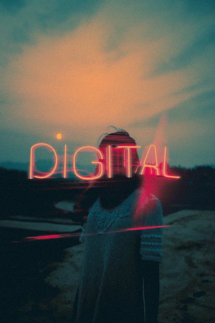 Silhouette of a woman at sunset with neon digital text against scenic backdrop.
