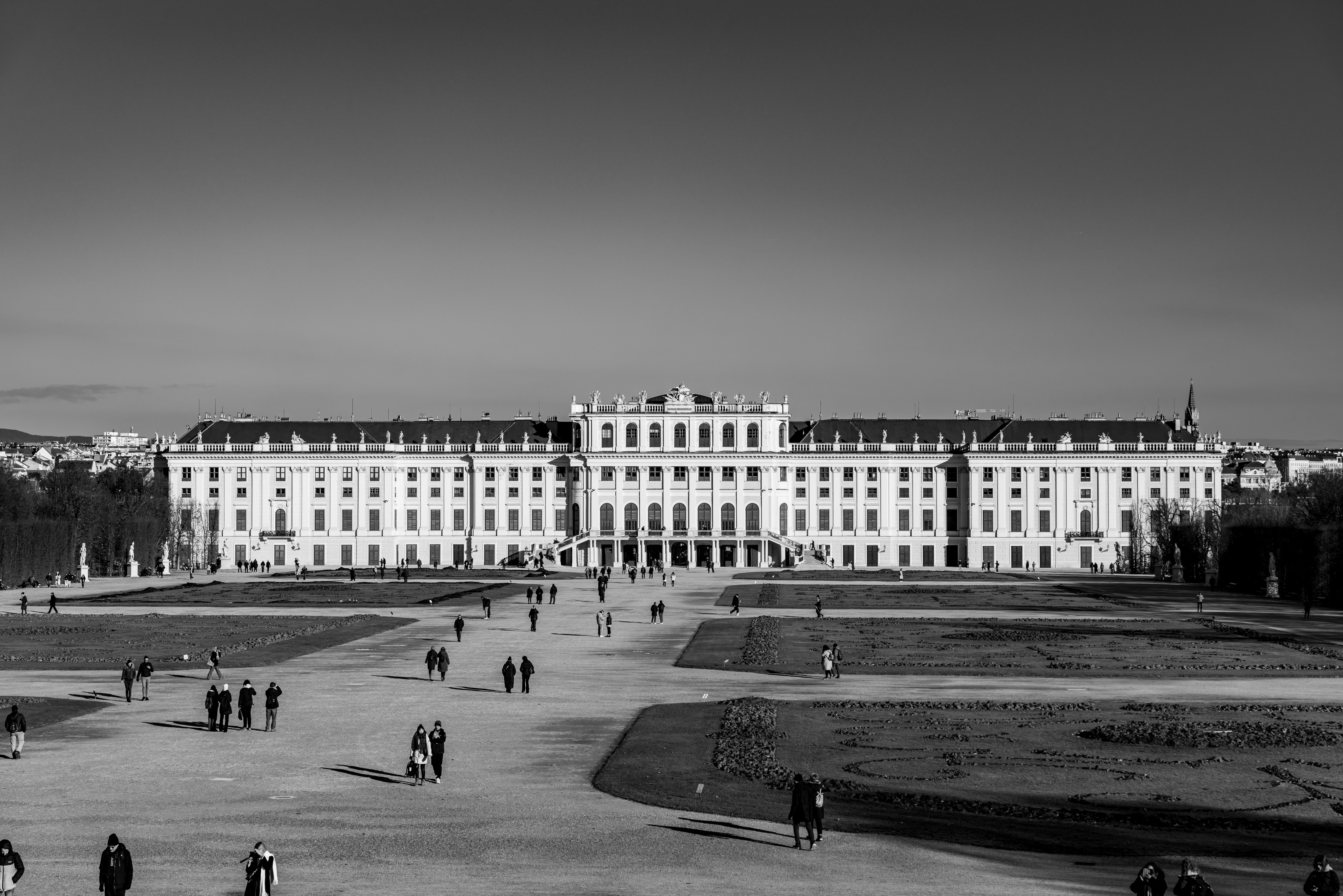 Timeless black and white capture of Schönbrunn Palace in Vienna with visitors.