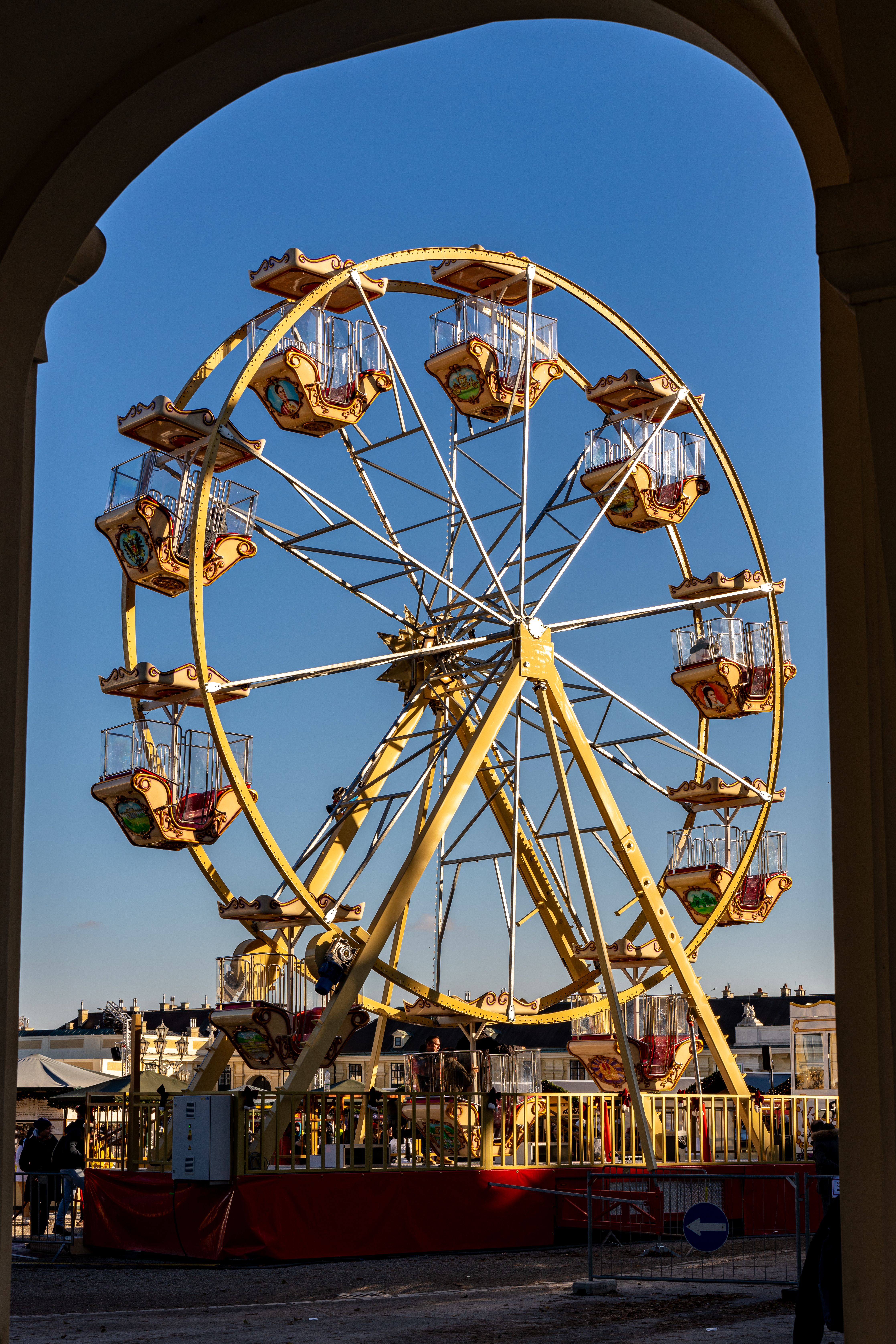 Colorful Ferris wheel under a clear blue sky in Vienna's Prater amusement park.