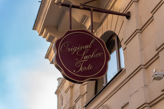 Detailed view of the Original Sacher Torte sign against a Viennese building facade.