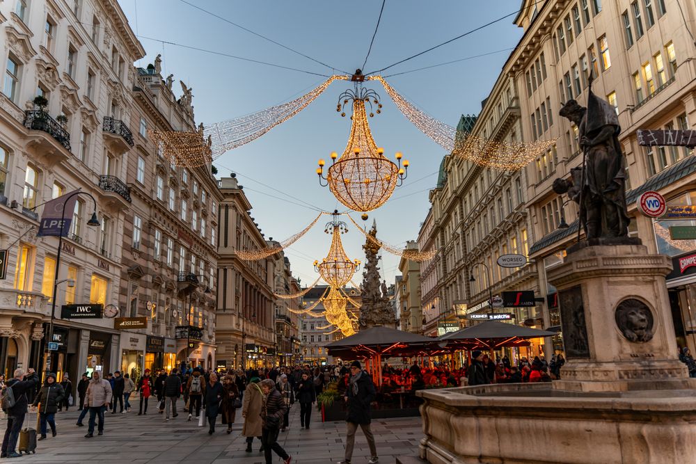 Strada Graben din Viena seara, cu iluminat decorativ suspendat și oameni plimbându-se
