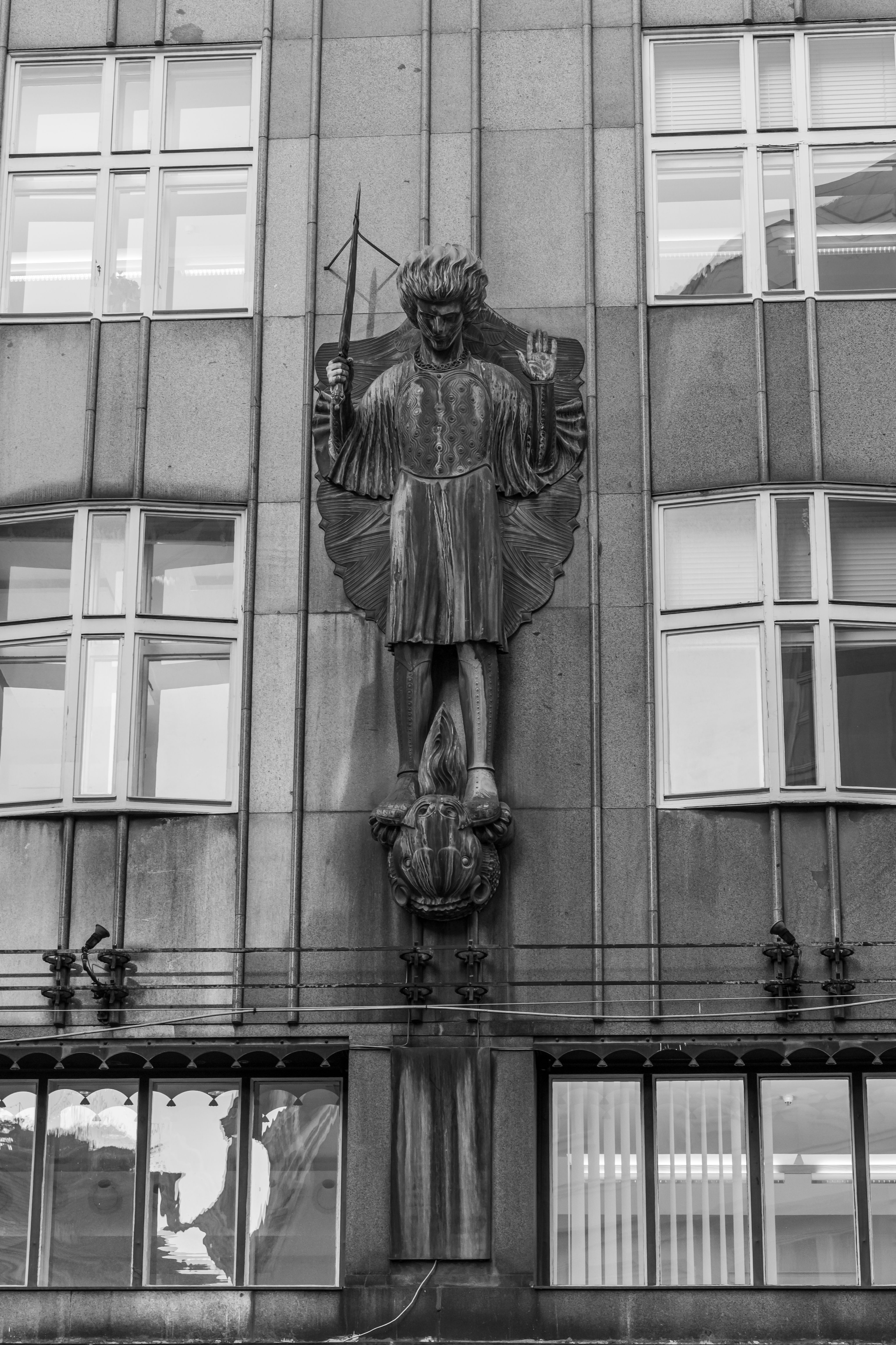Black and white photo of historic sculpture on building facade in Vienna, Austria.