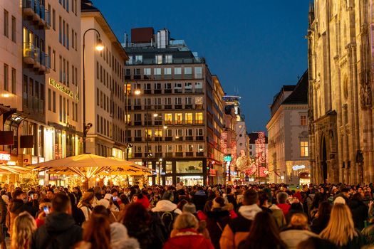A bustling night scene with a festive crowd in Vienna's vibrant city center.