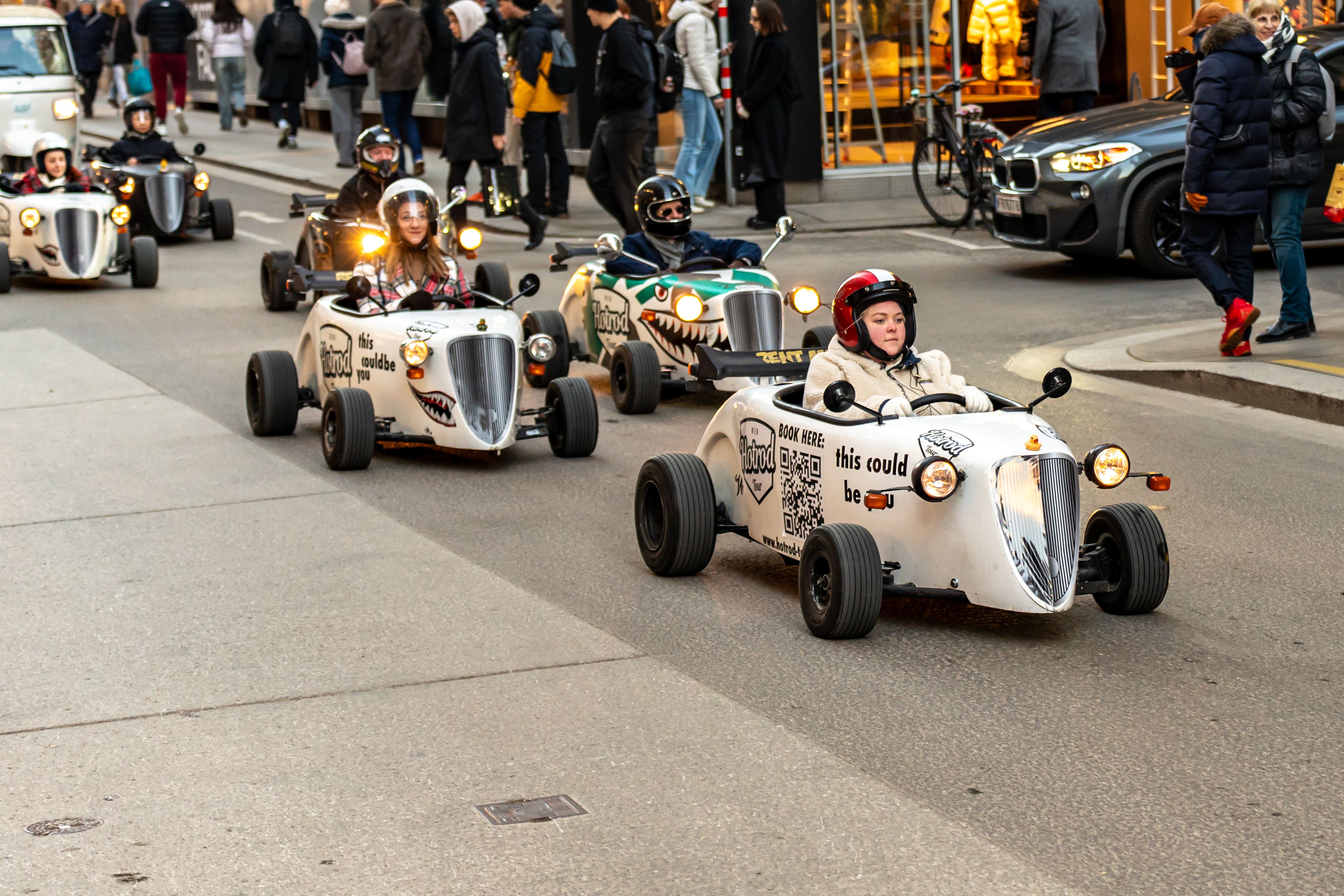 Colorful mini car parade on bustling streets of Vienna, Austria.