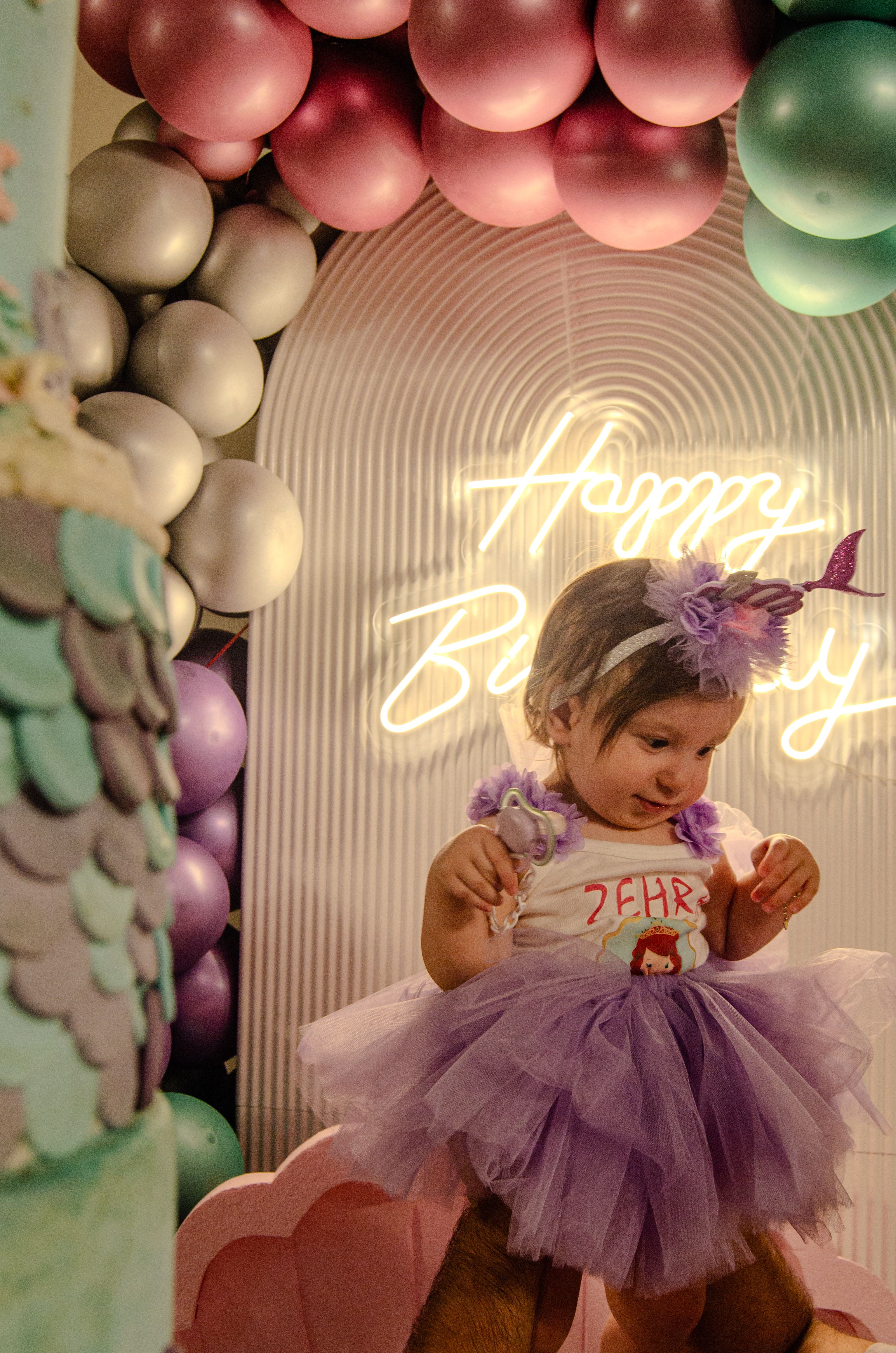 First birthday balloon decor ideas with pastel balloon garland backdrop framing a toddler's first birthday display