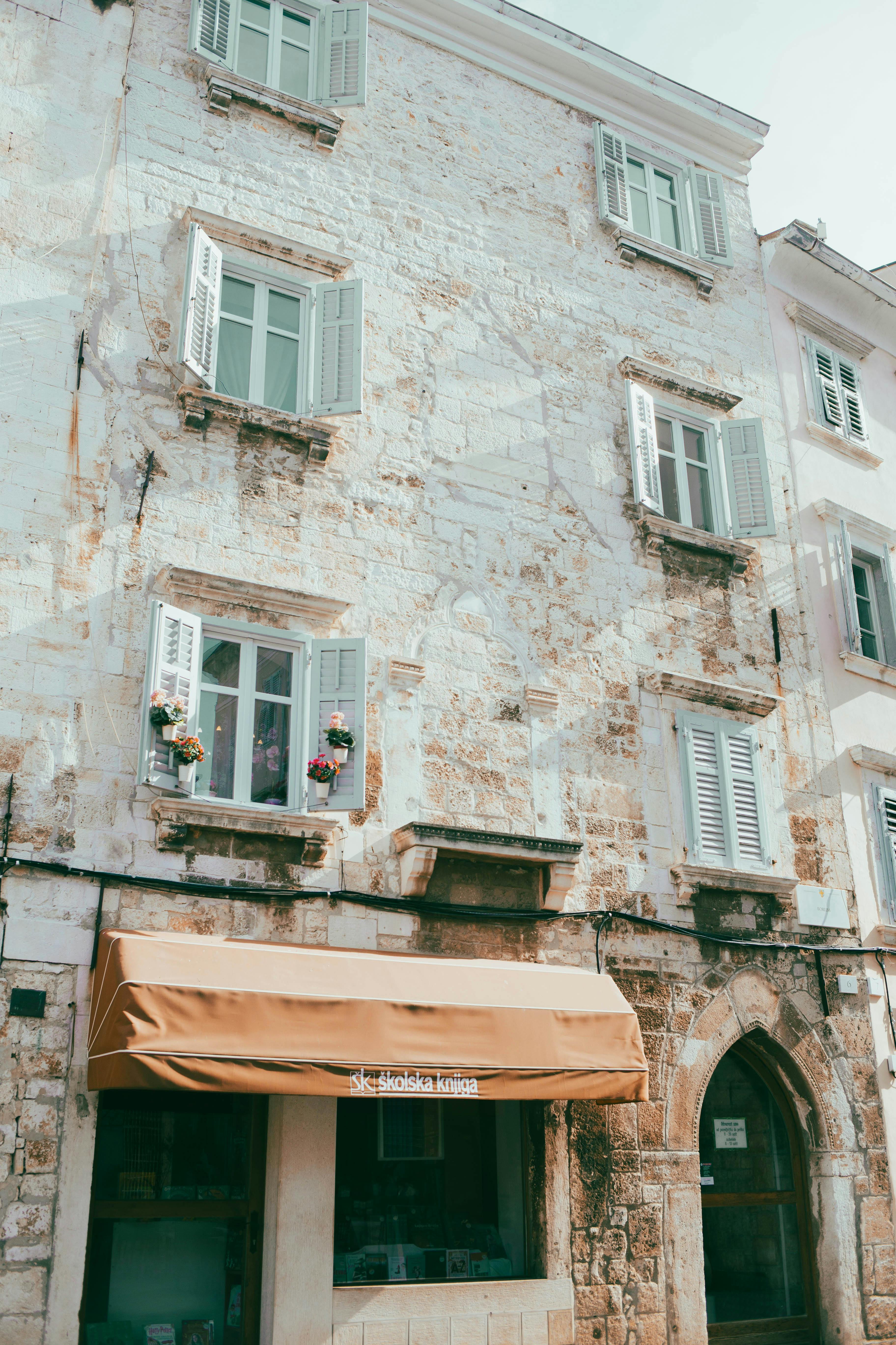 Explore the charming historic architecture of Pula, Croatia with rustic stone buildings and quaint windows.