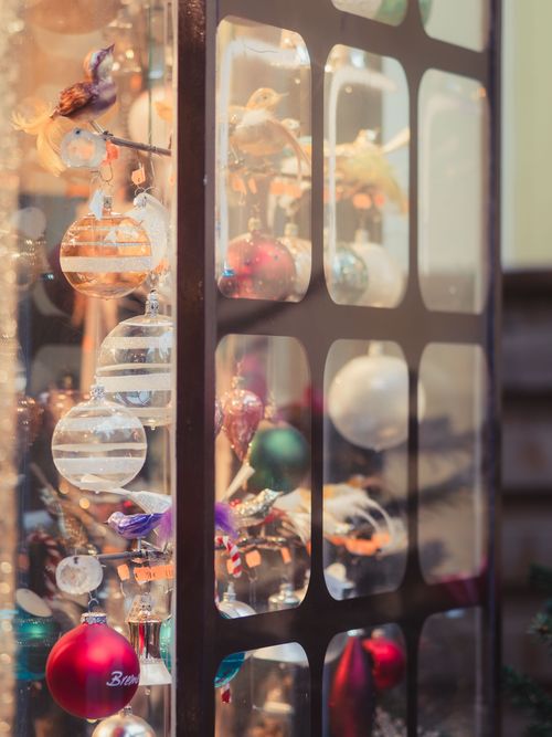 Free Close-up of colorful Christmas ornaments in a decorated display case, capturing festive spirit. Stock Photo
