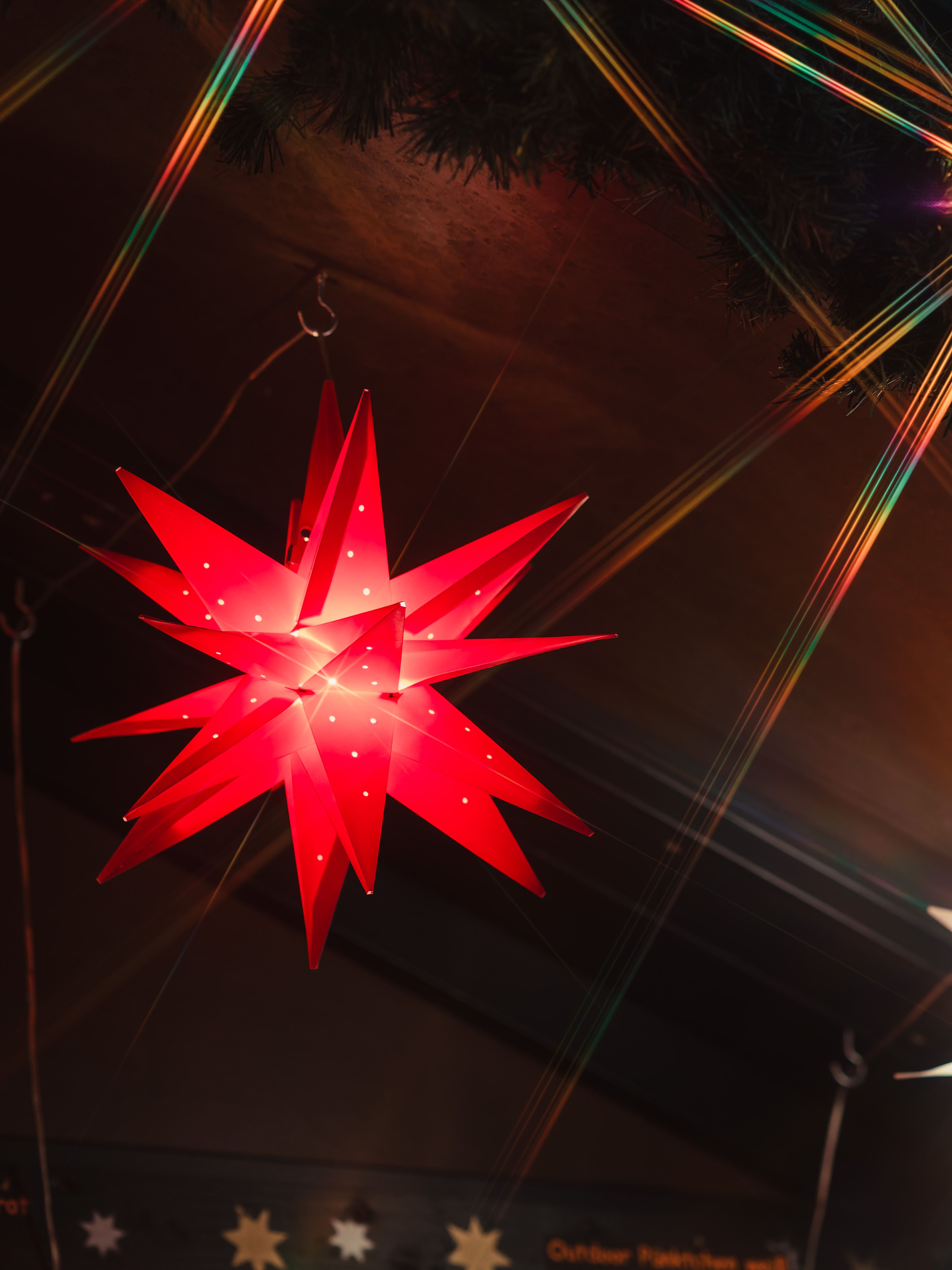 Festive red star decoration with lights at a Christmas market.