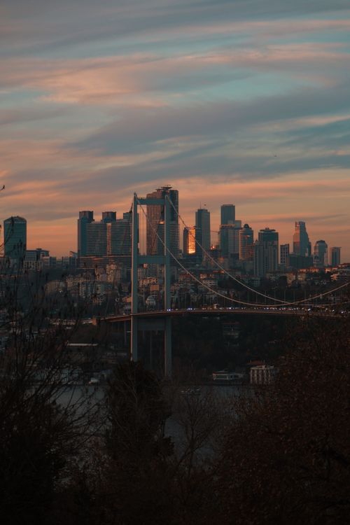 Free A stunning view of Istanbul's skyline with Bosphorus Bridge under a dramatic sunset sky. Stock Photo