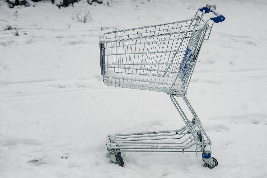 無料 雪の地面に灰色のショッピングカート 写真素材