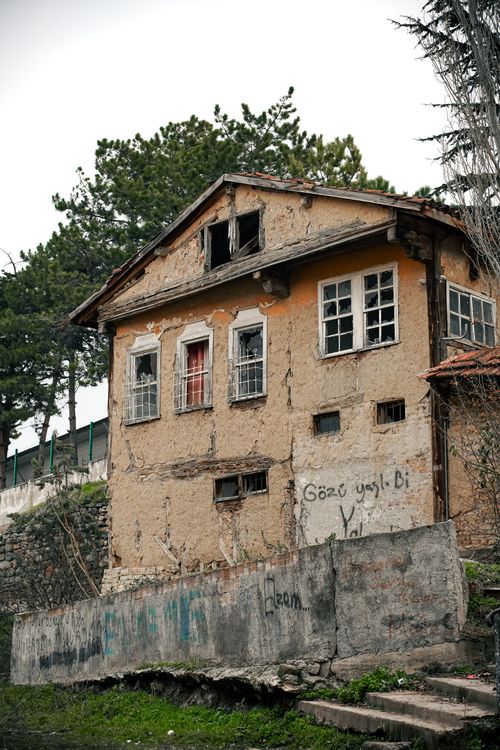 Free An old, abandoned house with worn walls and graffiti, surrounded by greenery. Stock Photo