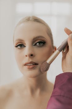 Elegant close-up of woman getting makeup done, highlighting flawless skin and beauty.