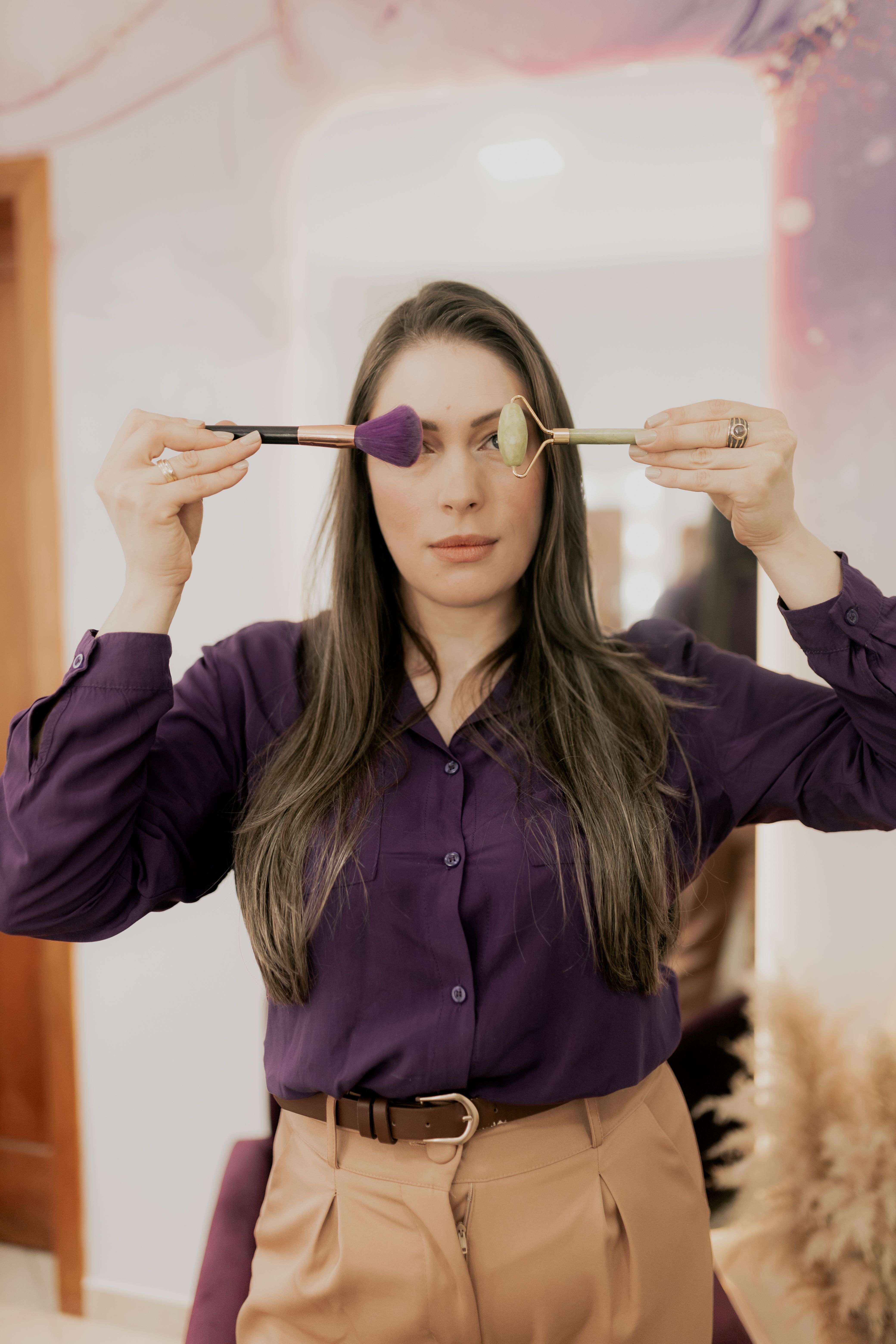Mulher elegante posa com pincéis de maquiagem destacando beleza e estilo.