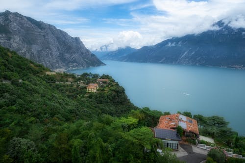 Free Scenic view of Lake Garda surrounded by the Italian Alps with lush greenery. Stock Photo