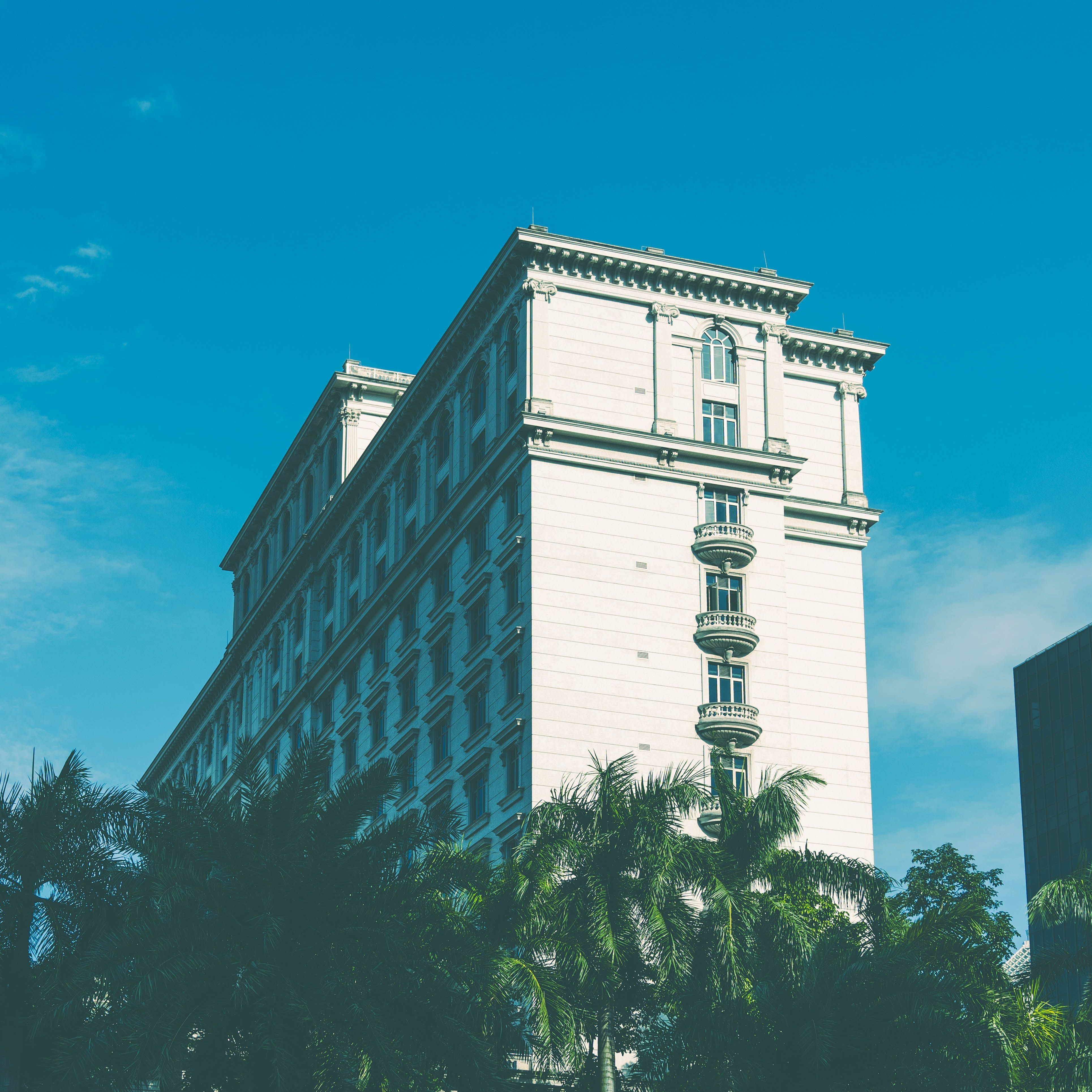 A classic white building in Zhuhai, China surrounded by lush greenery with a clear blue sky above.