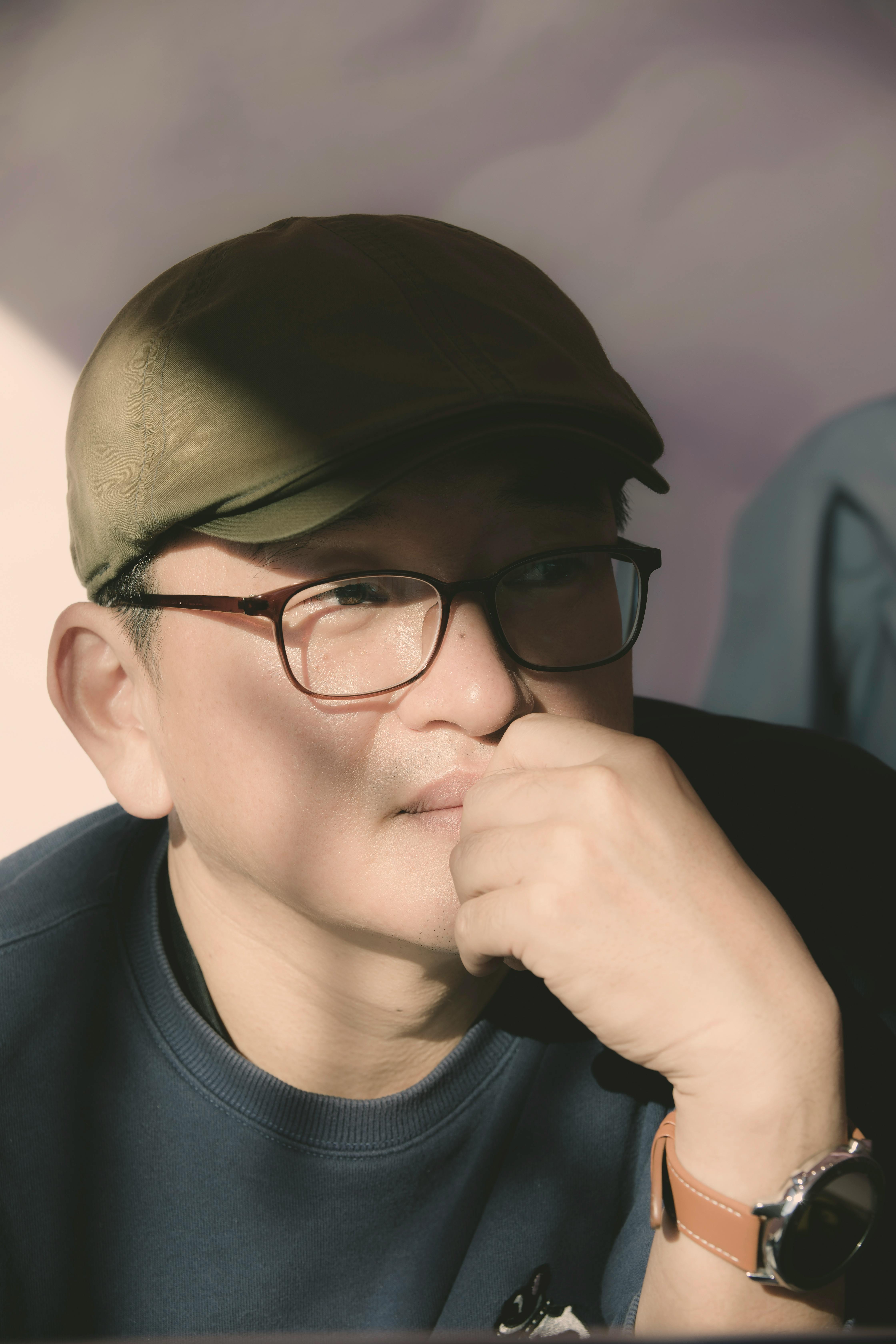 De franc Home amb gorra i ulleres, profund en els seus pensaments, amb la llum del sol projectant ombres. Foto d'estoc