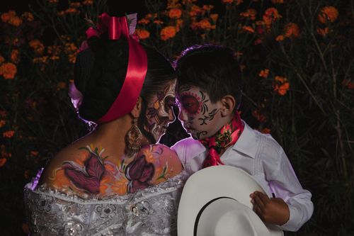 Free A mother and child celebrate Day of the Dead with traditional face paint and vibrant costumes. Stock Photo
