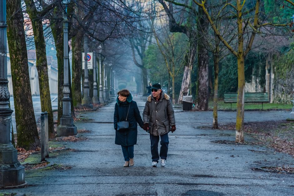 A healthy retired couple walking in a park enjoying their lifestyle