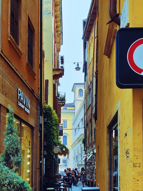 People Walking and Sitting on Alleyway