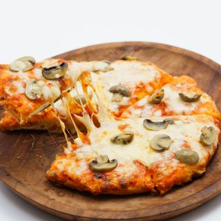Stone-baked mushroom pizza on a wooden board, photo by Kunal Lakhotia on Pexels