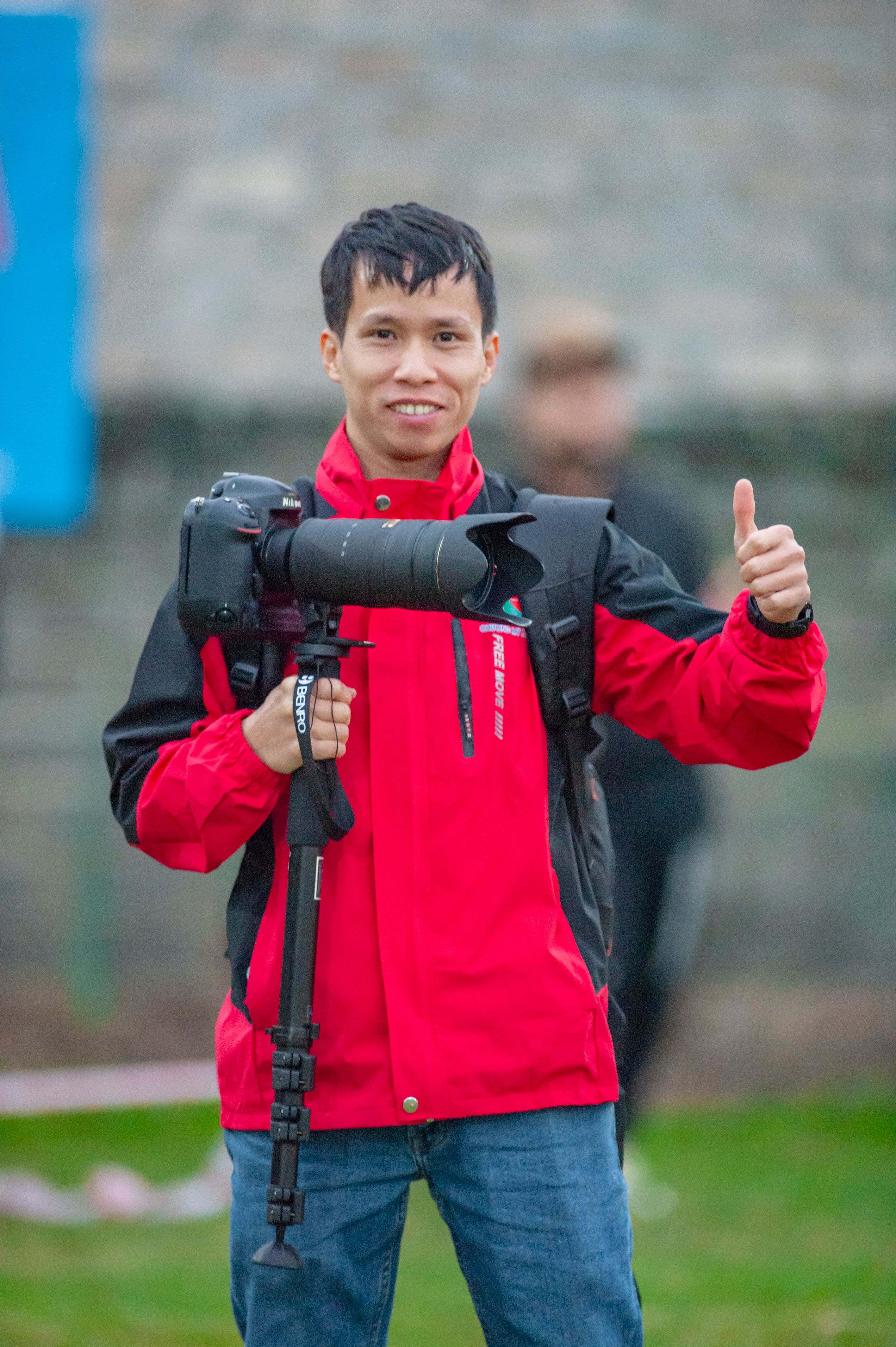 Photographer holding camera with long lens in Hanoi, giving thumbs up