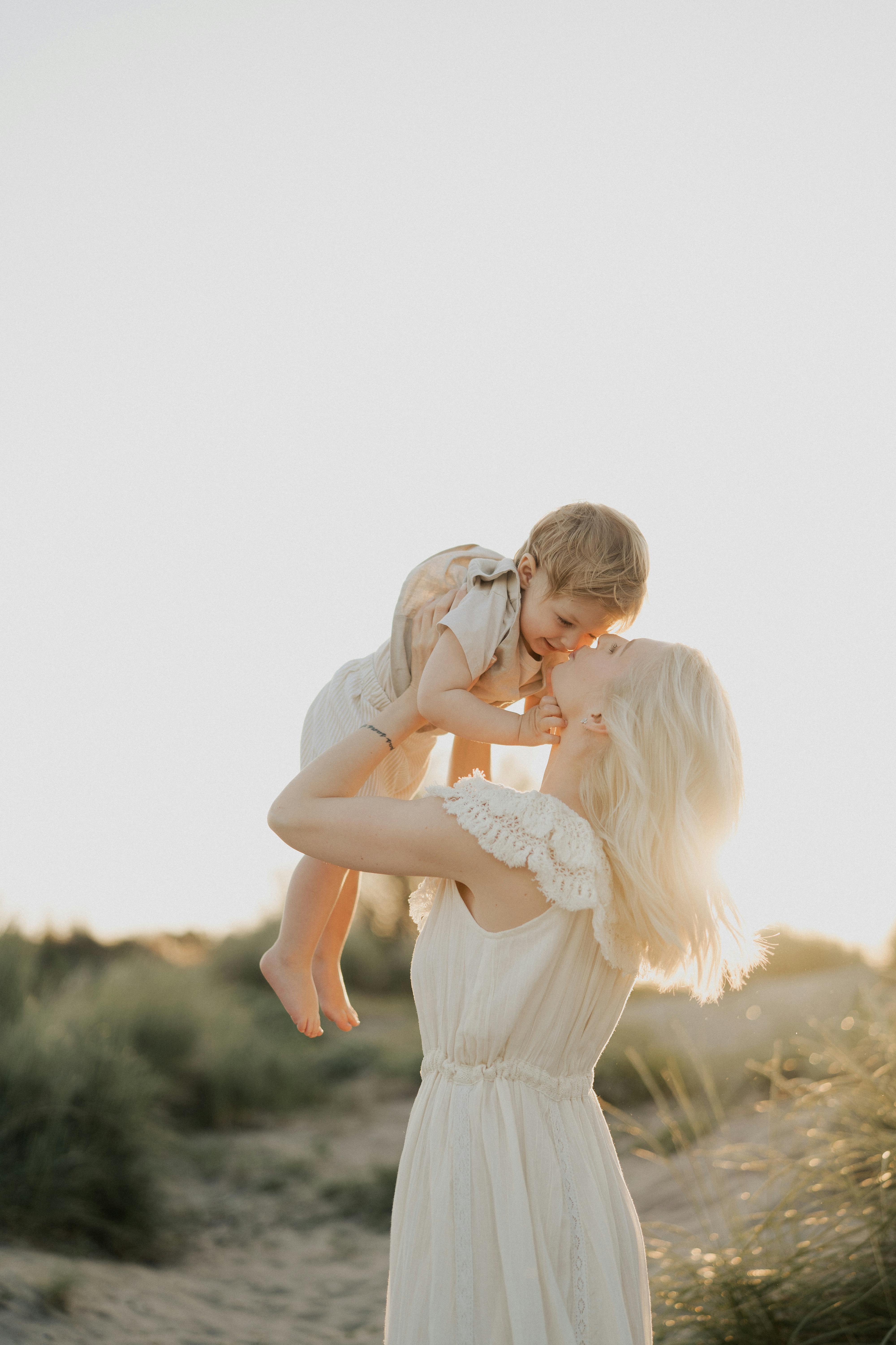 在日落时分，母亲在阳光明媚的海滩上拥抱孩子的宁静时刻